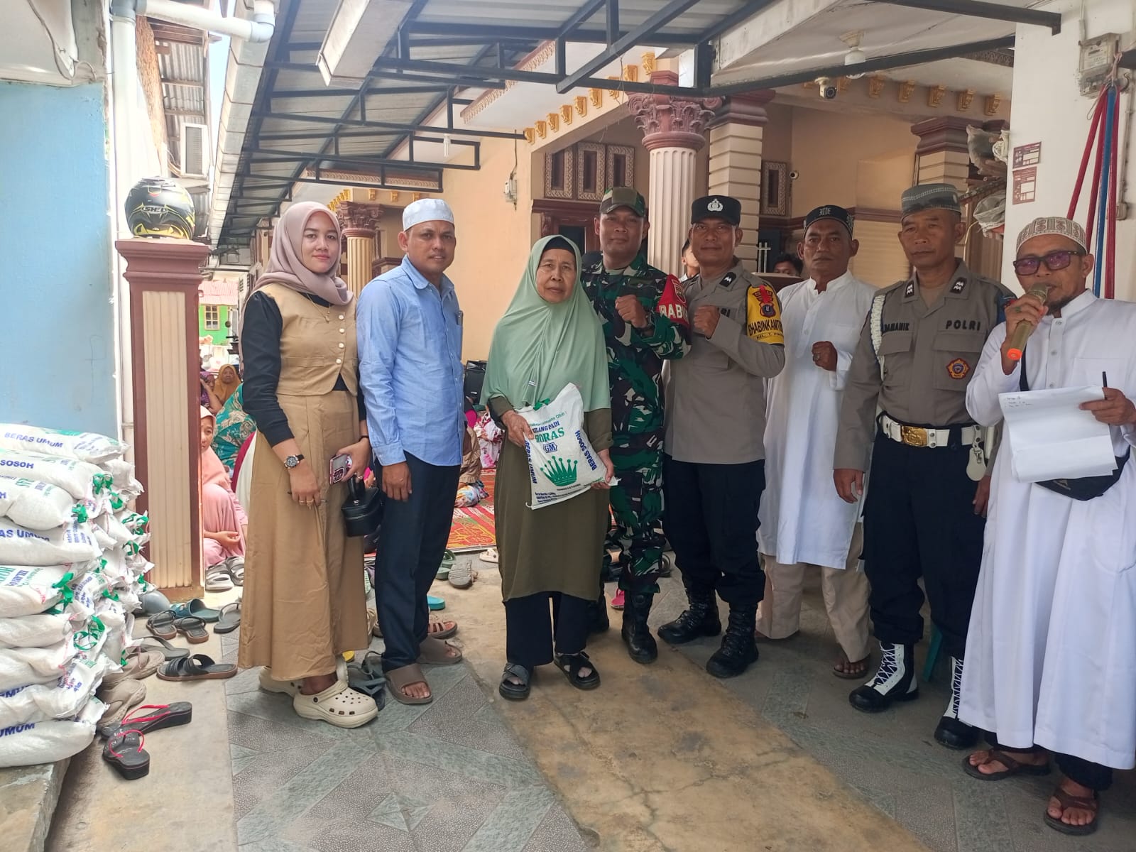 Bapak Sutikno bersama istri didampingi aparat penegak hukum (APH) dan para ulama menyerahkan zakat maal berupa sembako kepada warga.